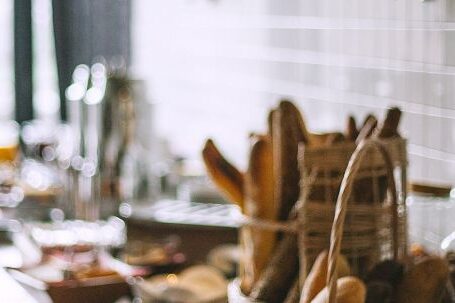 Profitable Catering. - Side view of delicious fresh baked baguette and buns in wicker basket and fresh baked pies and croissant in bakery in daytime