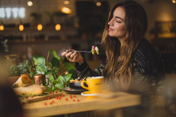 Restaurant - woman holding fork in front table