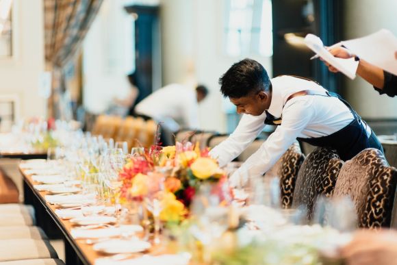 Restaurant Staff - man in white top standing next to table