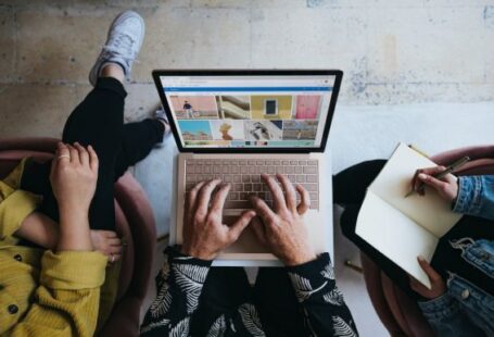 Marketing - person using microsoft surface laptop on lap with two other people